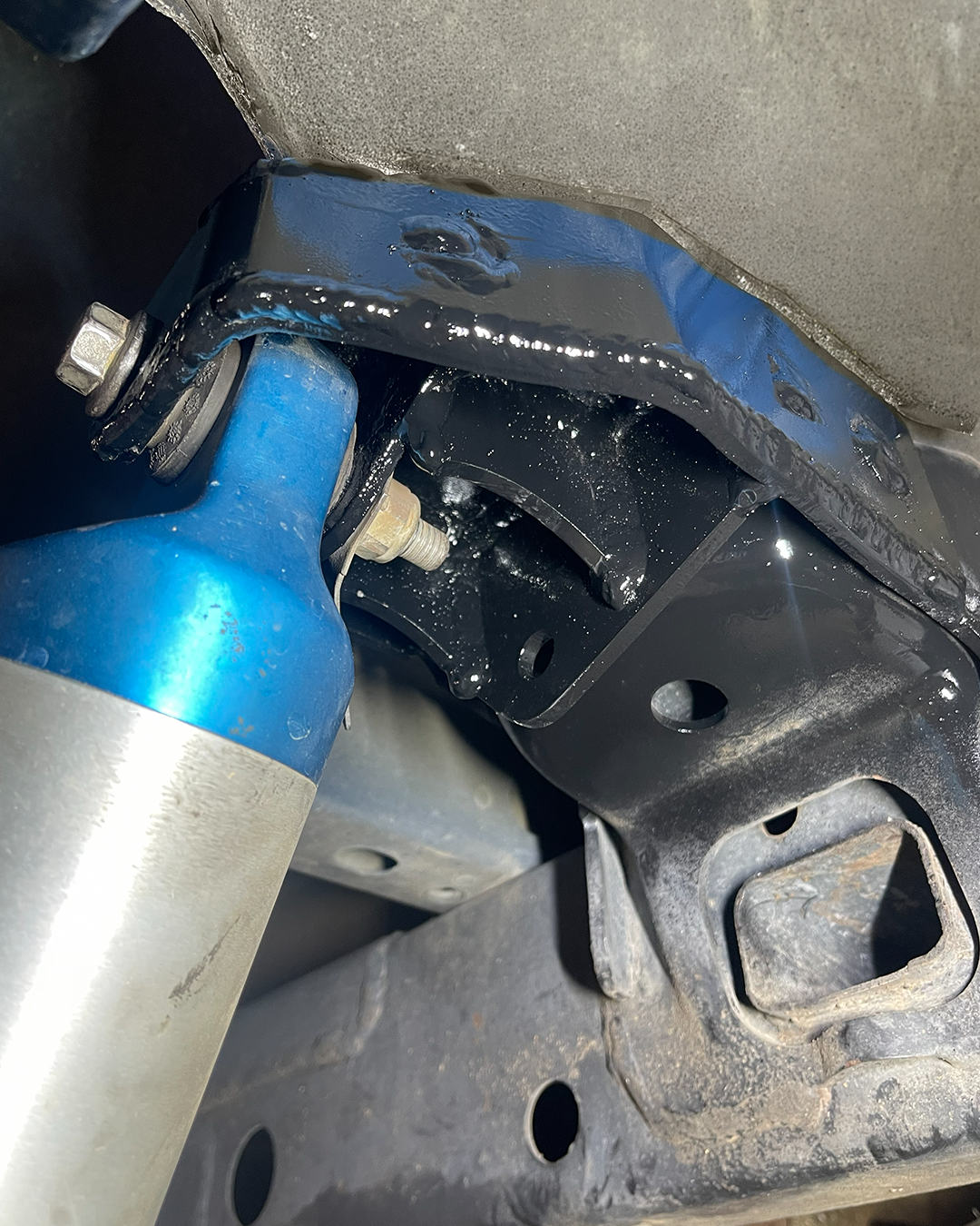 Gen 2 Raptor rear driver-side shock mount reinforcement installed with integrated limit strap mounting tab