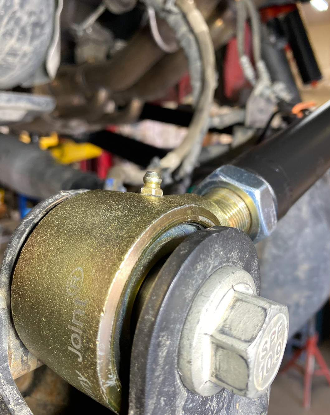 Forged Johnny Joint on the Gen 3 Raptor adjustable panhard bar, photographed close up with the truck on the lift