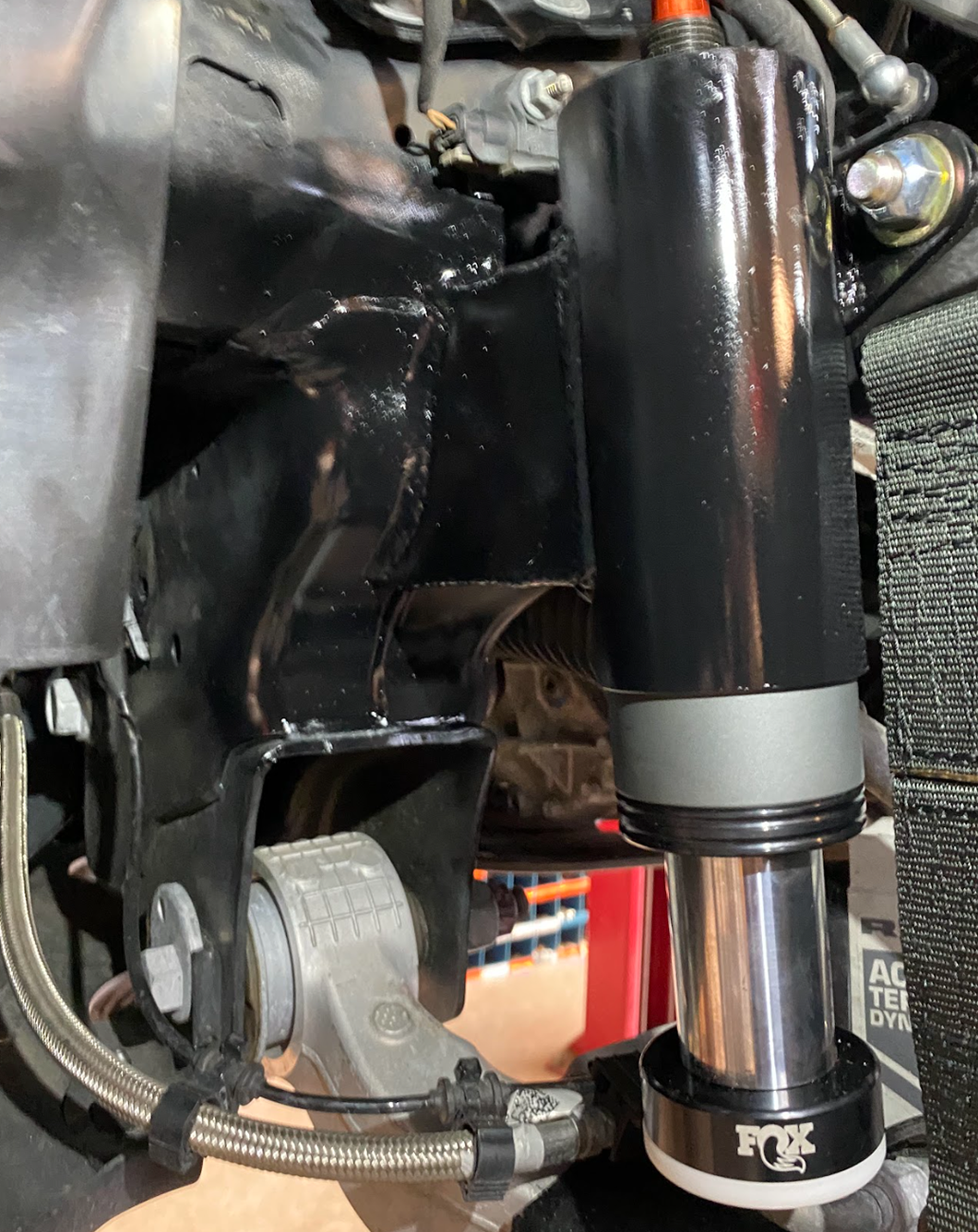 close up of a fox bump stop for a front limit strap kit installed on a ram trx