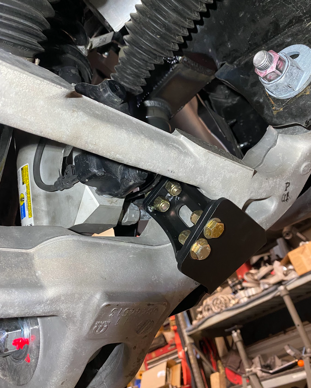 mounting bracket installed on a Stock lower arm of a Ram TRX for a Front Limit Strap with Bump Stop Stock kit