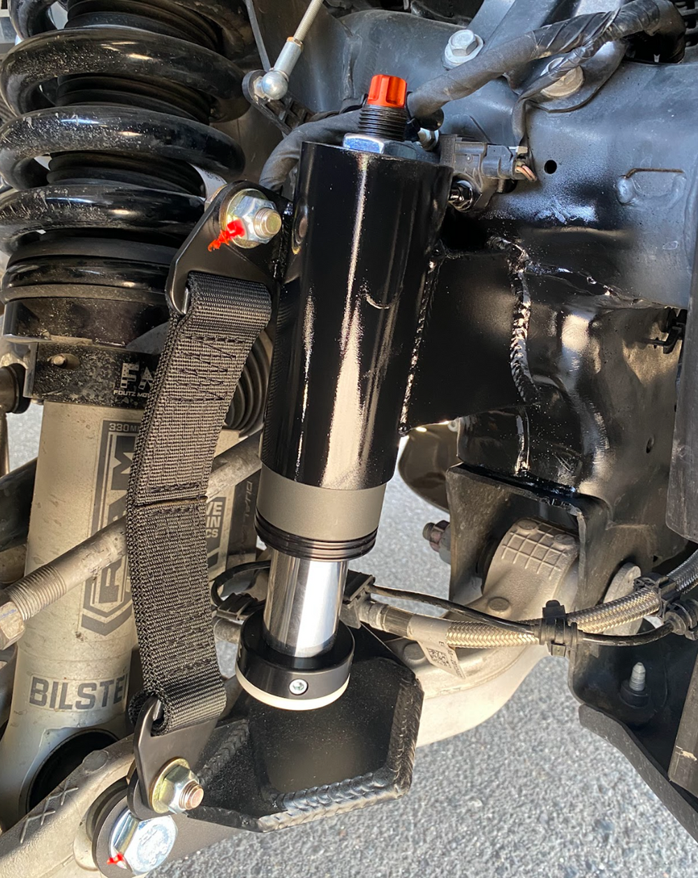 fox bump stop installed with a front limit strap on a stock lower control arm for a 2025 Ram RHO truck