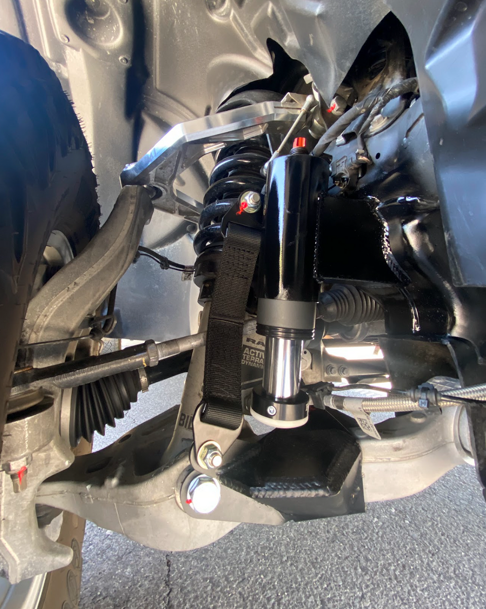 passenger side of 2025 Ram RHO with a Front Limit Strap & Bump Stop installed on a Stock Lower Arm