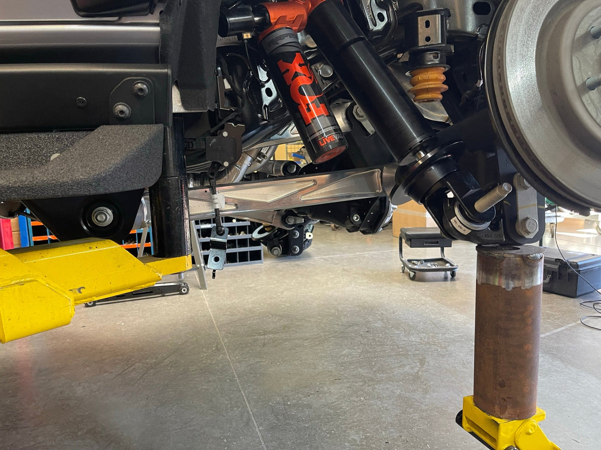 Bronco Raptor rear suspension on the lift during installation of raw billet rear arms