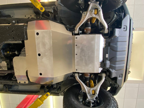 Aluminum skid plate installed under a Ford Bronco with the truck on a shop lift