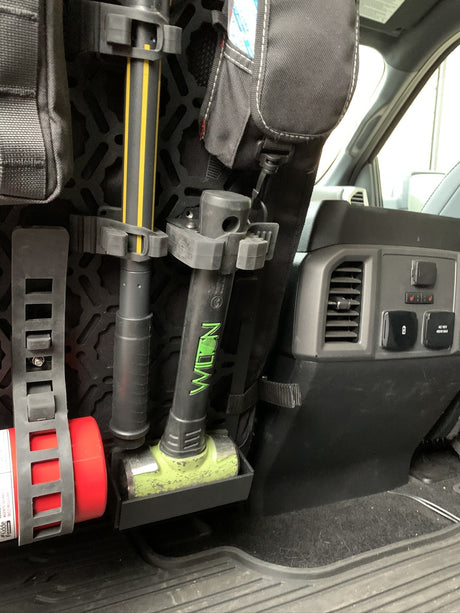 Off-road seat back panel organizer holding a shovel, hammer and fire extinguisher behind a truck seat