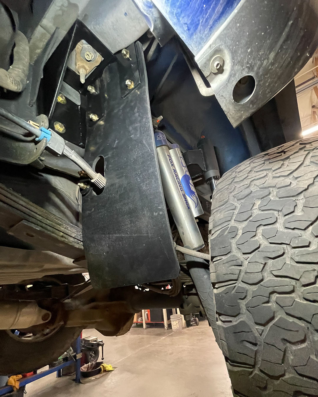 2010-2014 Raptor rear shock guard mud flap bracket with driver-side e-brake cable opening