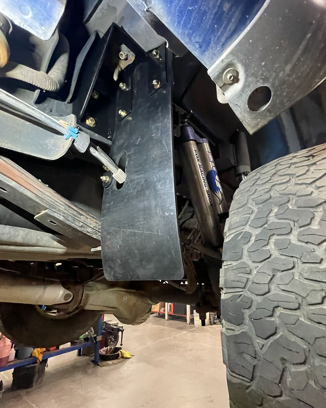 2010-2014 Raptor rear shock guard mud flap bracket with driver-side e-brake cable opening