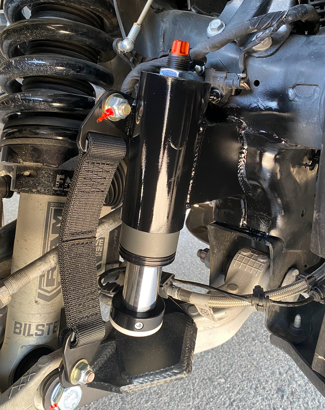 passenger side of a Front Limit Strap with Bump Stop Stock on a 2021-2024 Ram TRX 