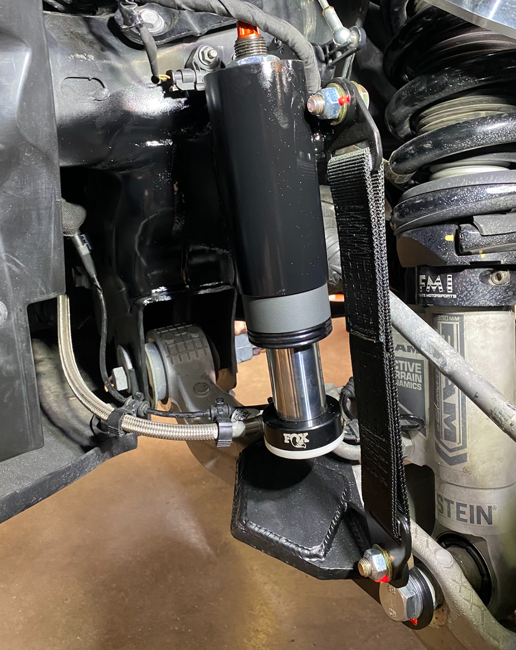 Close up of Stock lower arm Front Limit Strap with Bump Stop Stock for 2021-2024 Ram TRX suspension 