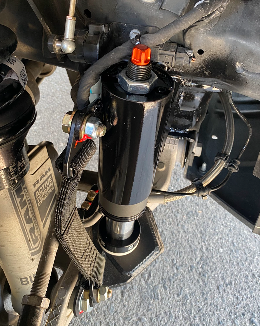 passenger side of a 2025 Ram RHO with a Front Limit Strap & Bump Stop installed on a Stock Lower Arm
