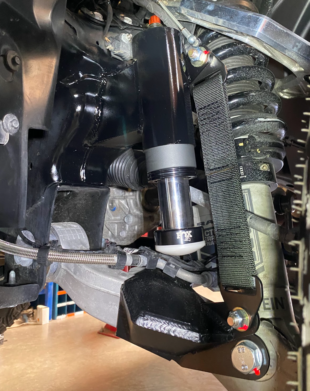 2025 Ram RHO Front Limit Strap & Bump Stop installed on a Stock Lower Arm