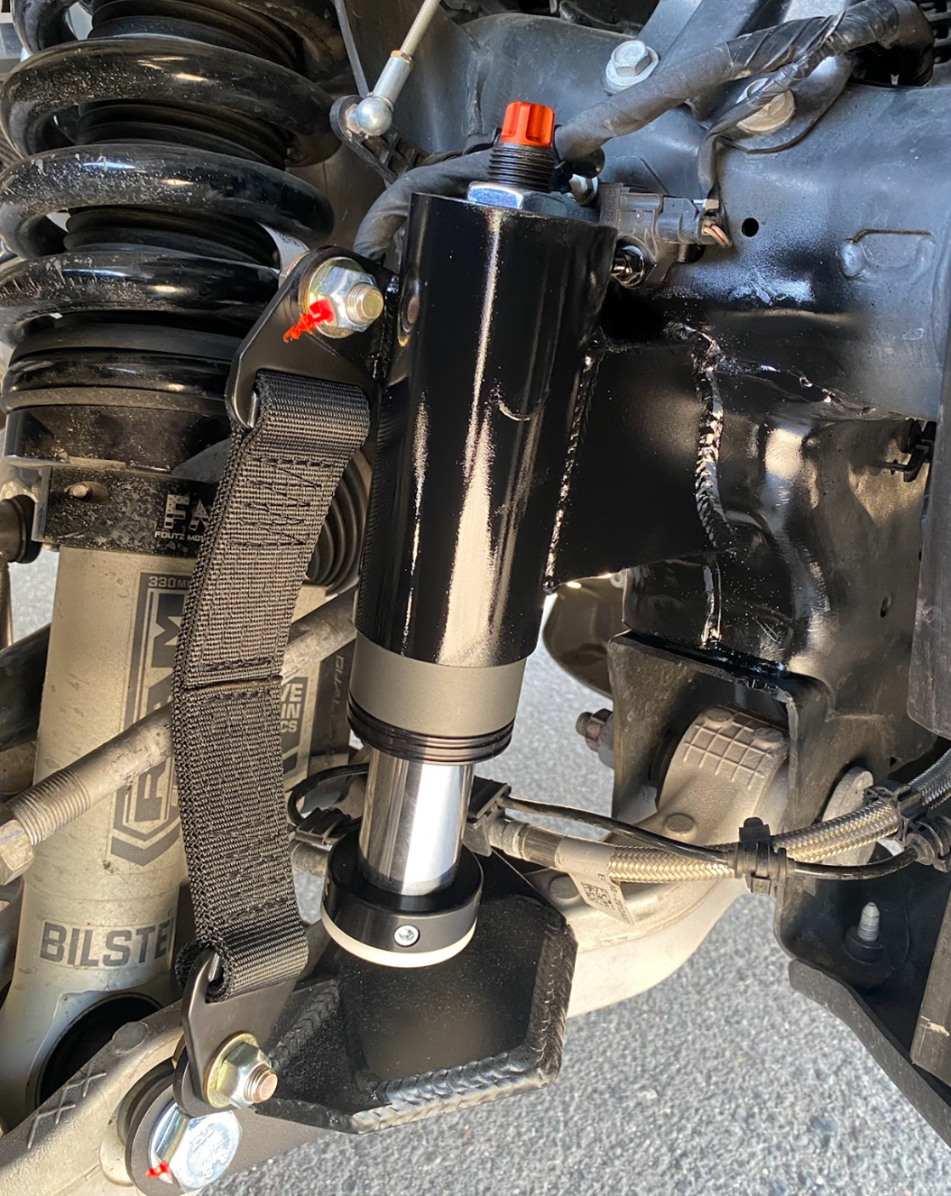 fox bump stop installed with a front limit strap on a stock lower control arm for a 2025 Ram RHO truck