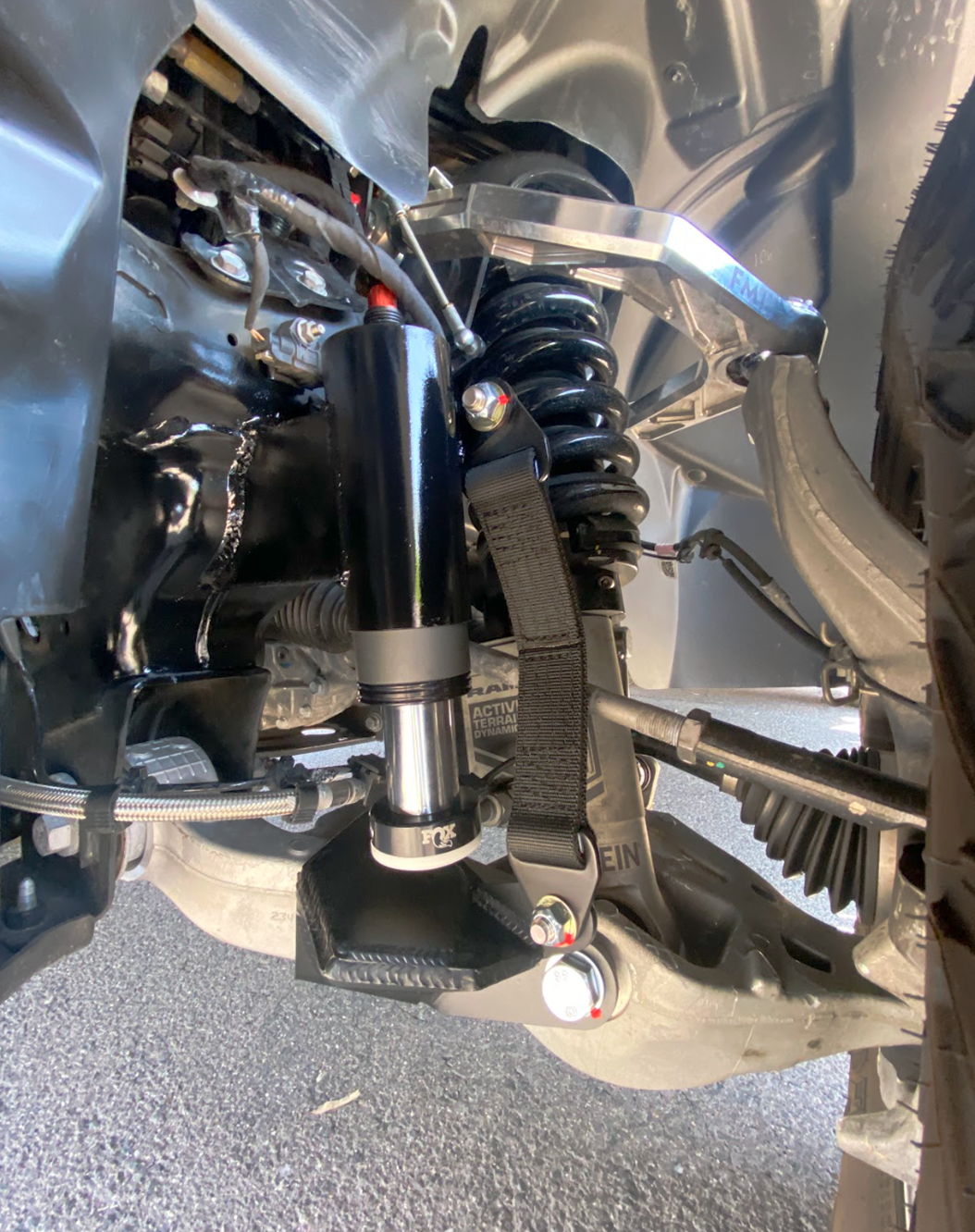 drivers side of 2025 Ram RHO with a Front Limit Strap & Bump Stop installed on a Stock Lower Arm