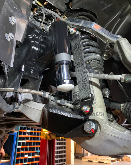 drivers side of 2025 Ram RHO with a Front Limit Strap & Bump Stop installed on a Stock Lower Arm