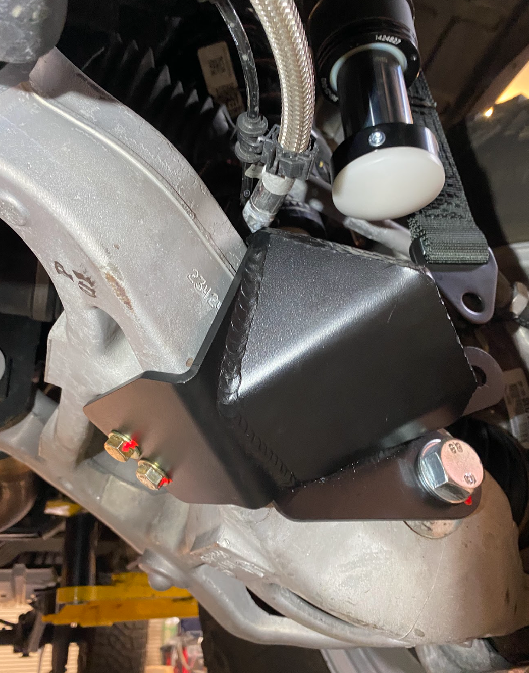Mounting bracket installed on a Ram RHO stock lower control arm for a Front Limit Strap kit with Bump Stop 
