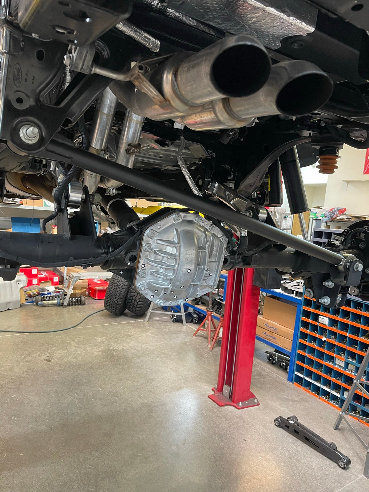 Underside view toward the rear axle of a Bronco Raptor fitted with raw billet rear arms