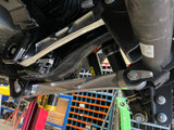 Raw billet upper rear arm at the axle bracket beside the rear shock on a Bronco Raptor