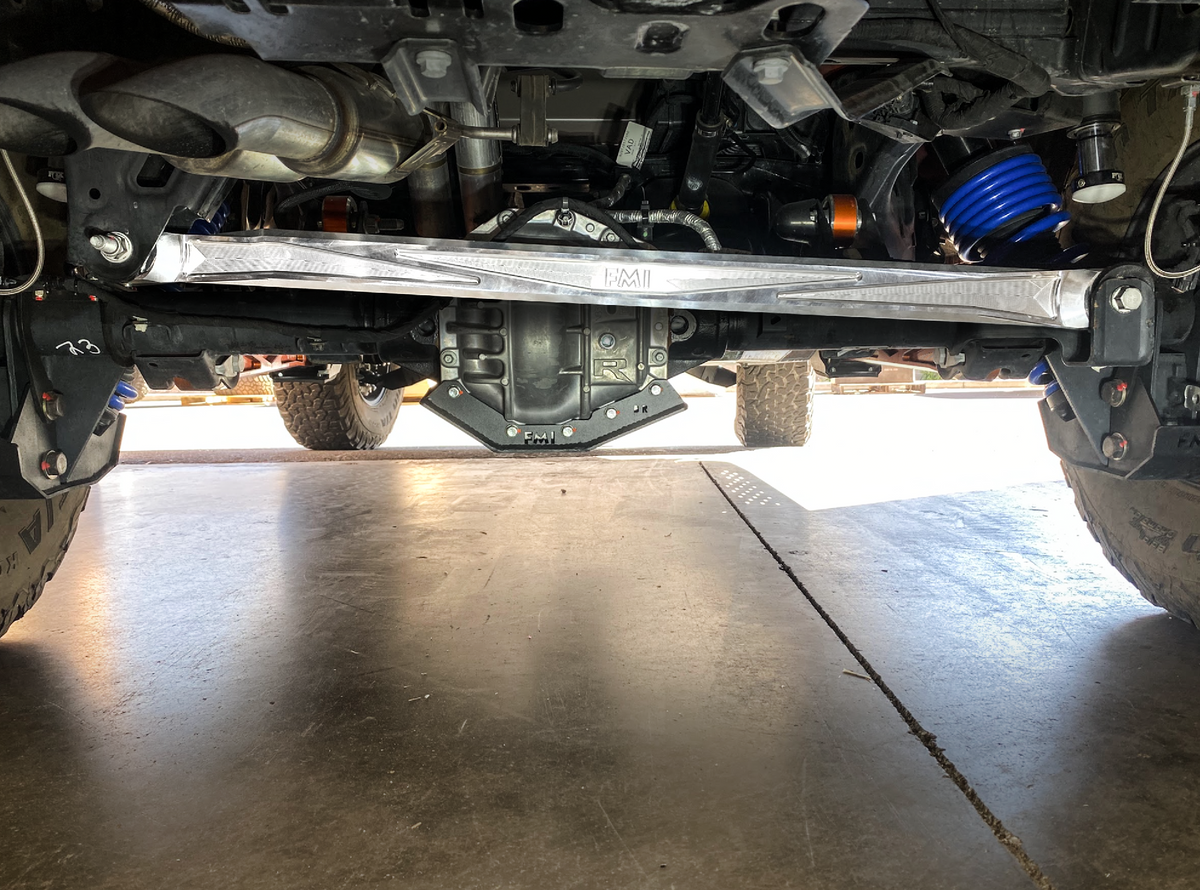 Rear view straight across a Bronco Raptor axle showing the full length of a raw billet panhard bar
