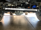 Rear view straight across a Bronco Raptor axle showing the full length of a raw billet panhard bar