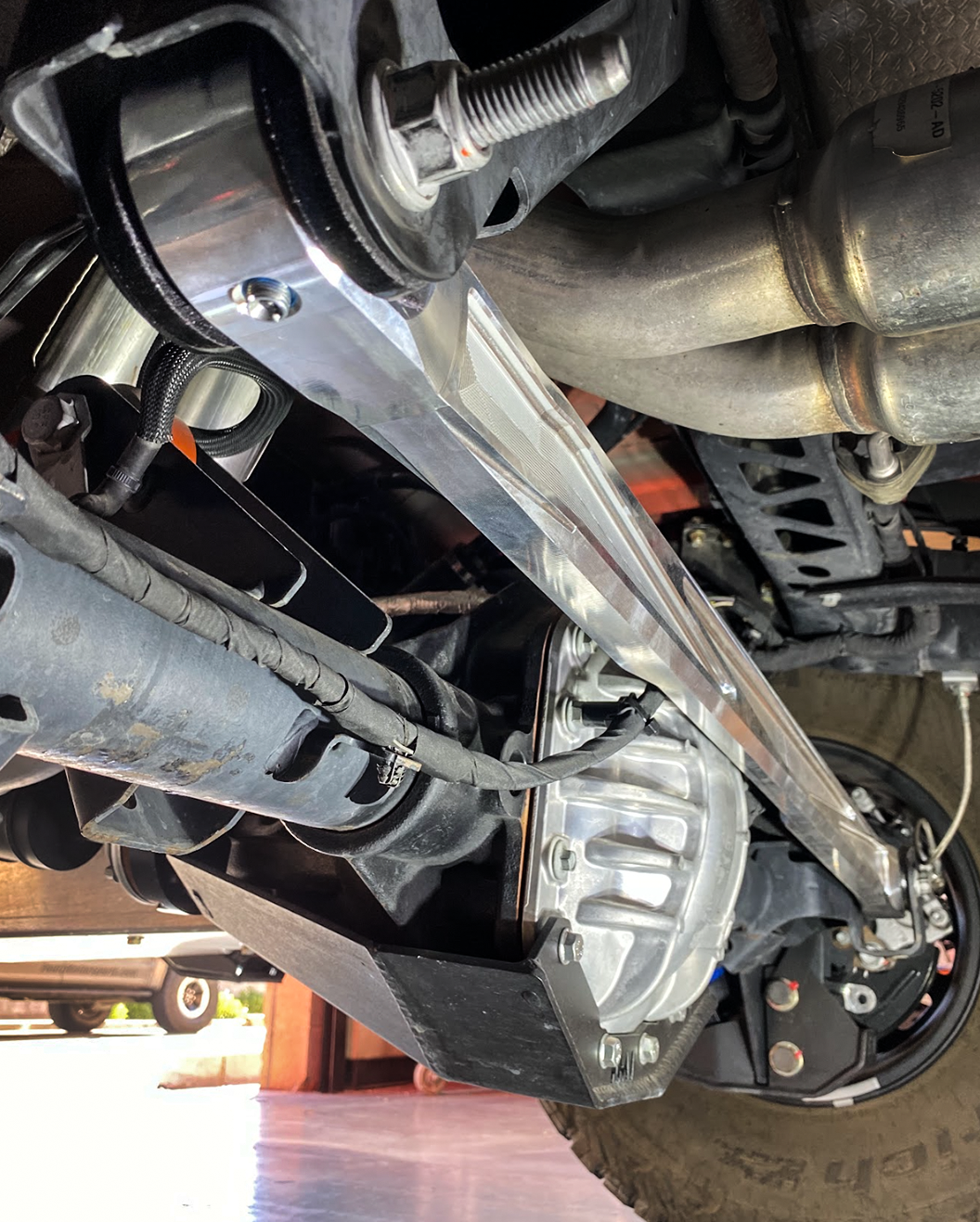 Raw billet panhard bar close to the differential on a Bronco Raptor, angled view from below