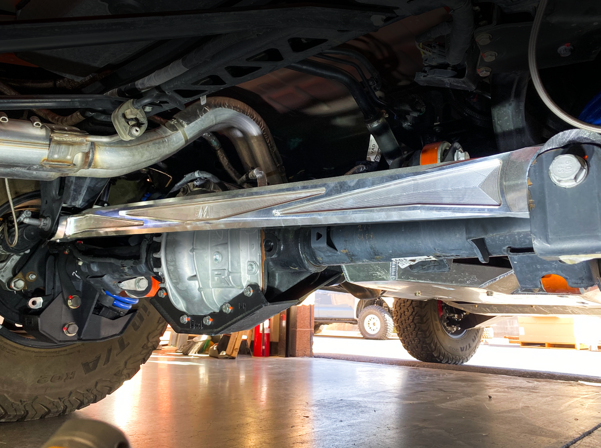 Angled rear view of a raw billet aluminum panhard bar installed on a Ford Bronco Raptor