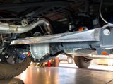 Angled rear view of a raw billet aluminum panhard bar installed on a Ford Bronco Raptor