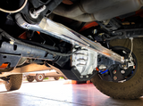 Raw billet Bronco Raptor panhard bar spanning the rear axle, seen from the rear wheel side
