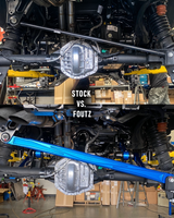 Stock vs Foutz: factory Bronco Raptor panhard bar above a blue anodized FMI billet panhard bar on the same rear axle