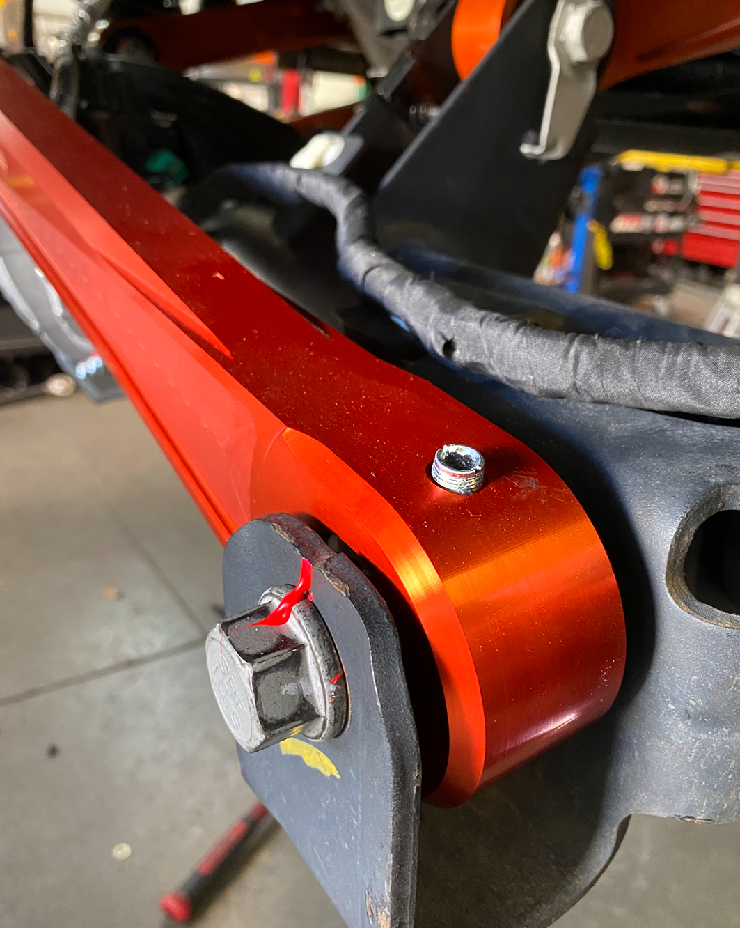 Close-up of a FOX orange anodized billet panhard bar end with Ultra-Flex joint at the axle mount