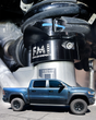 Black anodized FMI 2.5" leveling collar installed under the front coil spring of a 2027 Ram TRX, with a side view of the leveled truck inset