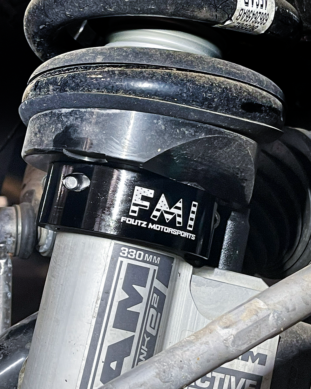 Black anodized billet 2.5" leveling collar seated below the factory front coil spring perch on a 2027 Ram TRX