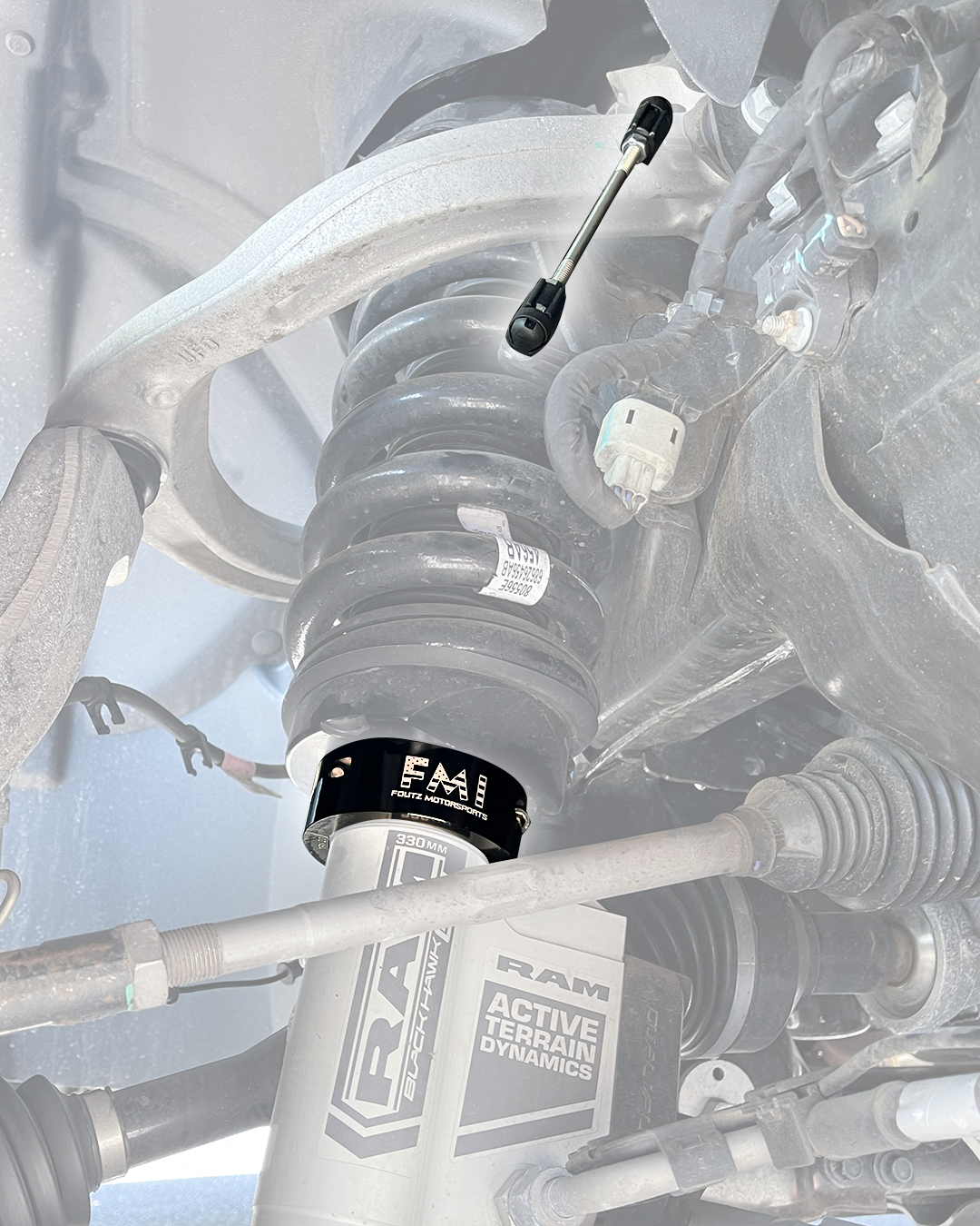 2027 Ram TRX front suspension with the adjustable ride height sensor connector rod highlighted above a black anodized 2.5" lift collar